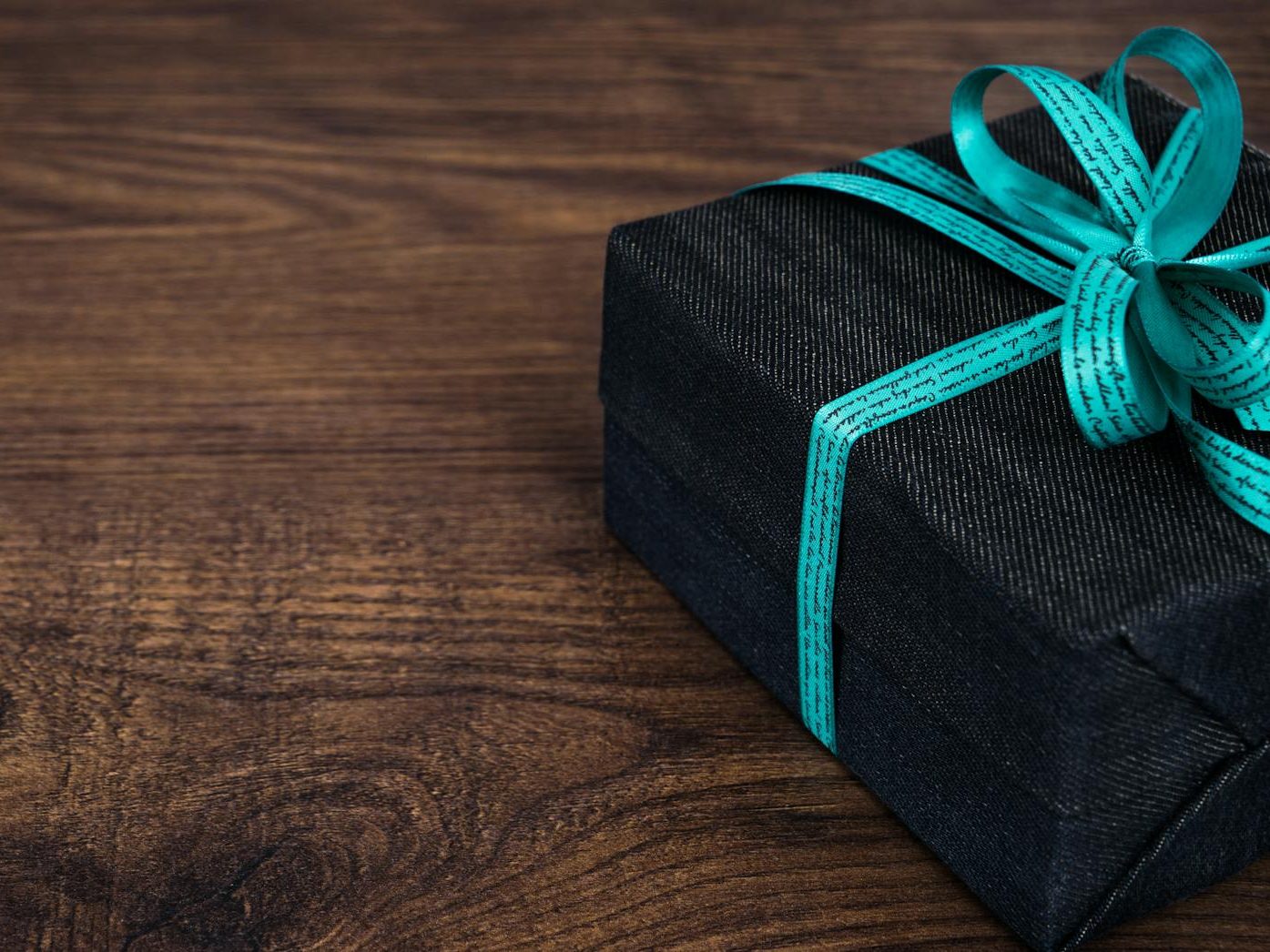 black gift box on wooden surface